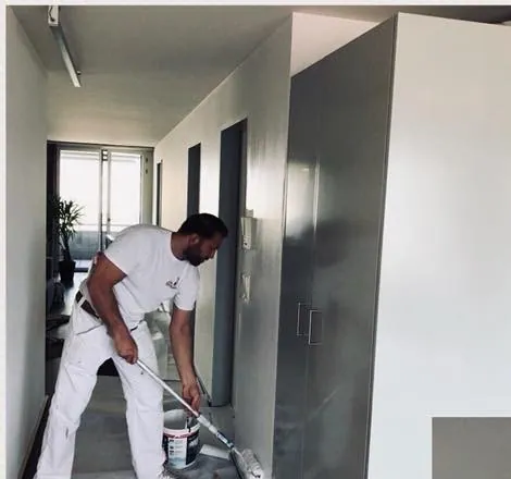 Maler streicht eine Wand im Flur